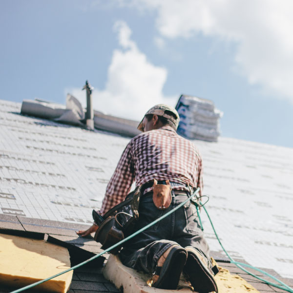 roofer adding shingles to the roof of a house 2RGW2FZ South Florida Metal Roofing Experts